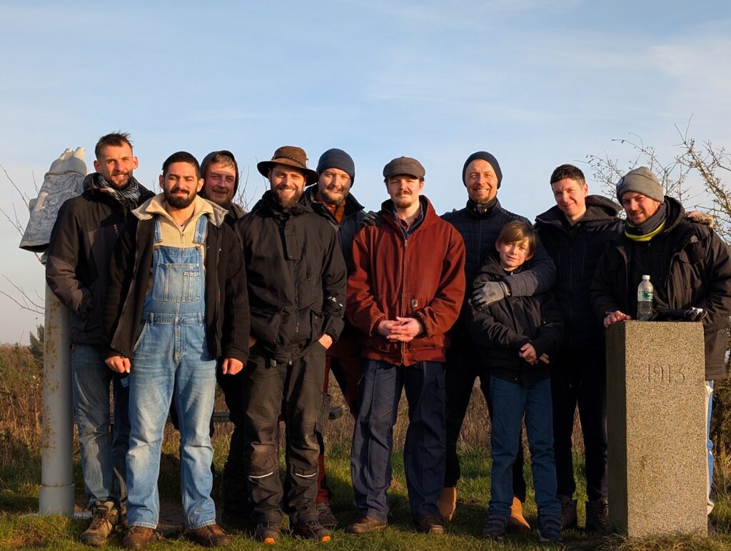 Men of the brotherhood standing together outdoors at a gathering on the farm on Fyn, Denmark
